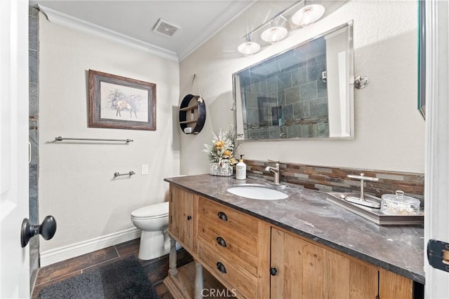 bathroom featuring backsplash, crown molding, toilet, vanity, and hardwood / wood-style flooring