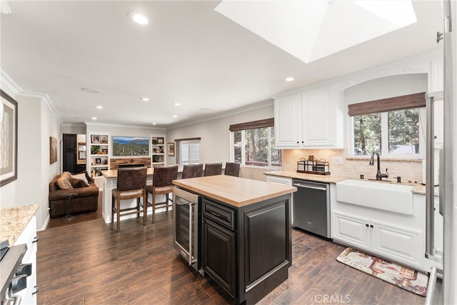 kitchen featuring dark hardwood / wood-style flooring, dishwasher, a center island, and sink