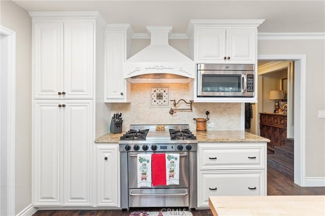 kitchen featuring custom exhaust hood, dark hardwood / wood-style floors, white cabinetry, and appliances with stainless steel finishes