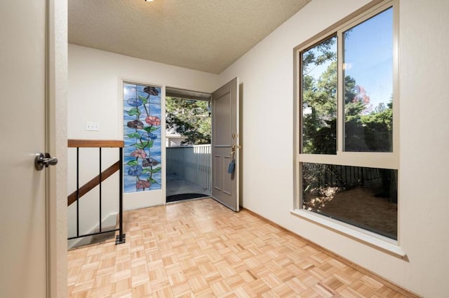 doorway featuring light parquet floors and a textured ceiling