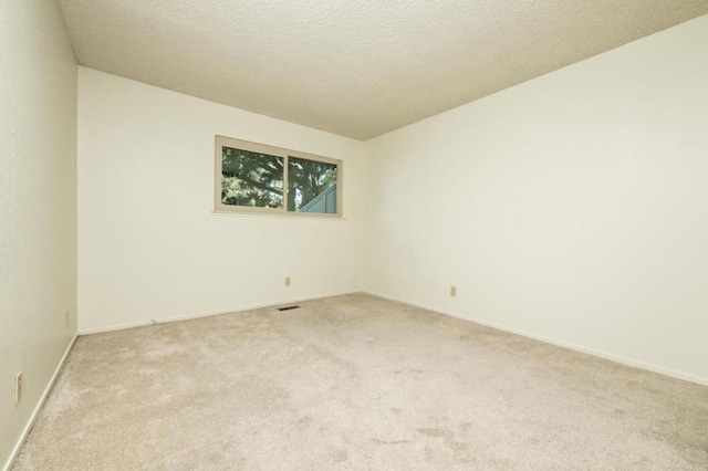 carpeted spare room featuring a textured ceiling