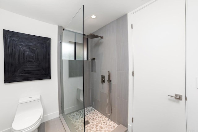 bathroom featuring recessed lighting, baseboards, toilet, and a stall shower