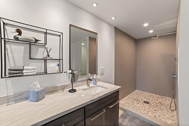 full bathroom featuring recessed lighting, tiled shower, and vanity