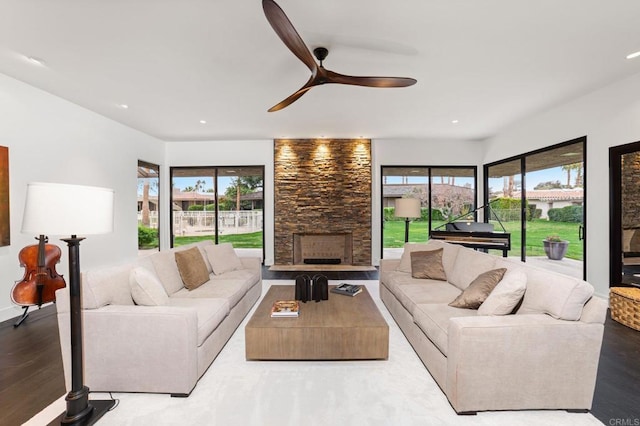 living room featuring a stone fireplace, recessed lighting, a wealth of natural light, and ceiling fan