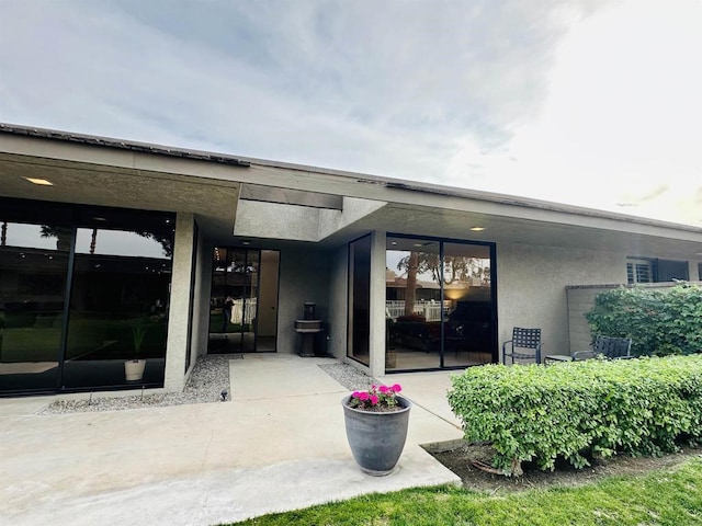 back of property featuring stucco siding and a patio