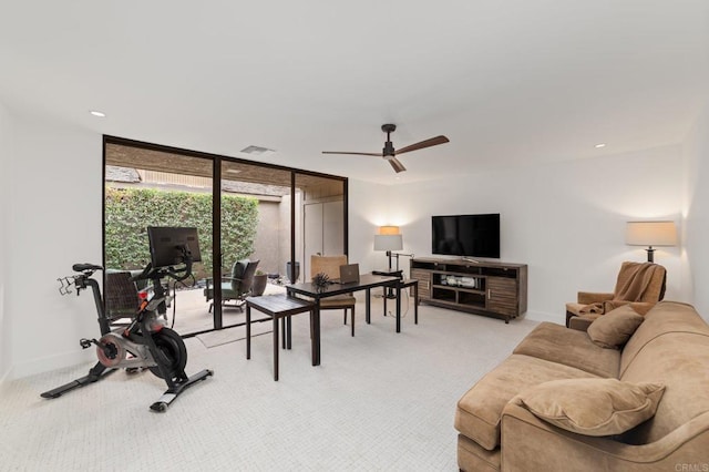 living area featuring expansive windows, a ceiling fan, baseboards, and light carpet