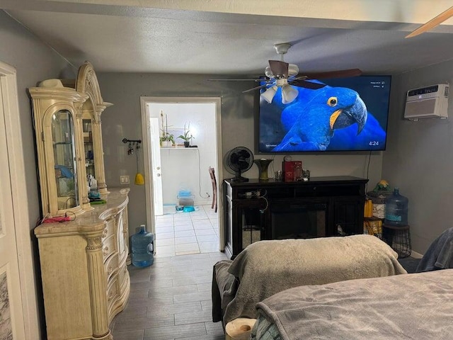 bedroom with ceiling fan, hardwood / wood-style floors, and a wall mounted air conditioner