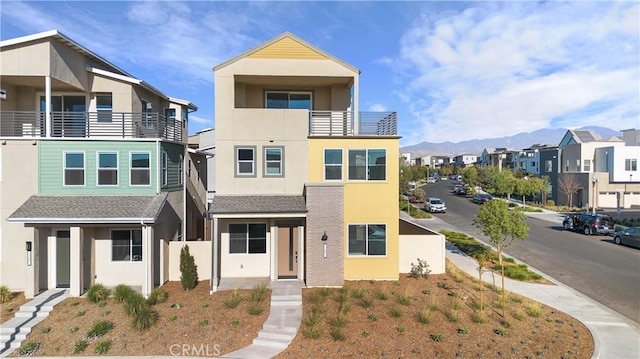 view of front of property featuring a mountain view and a balcony