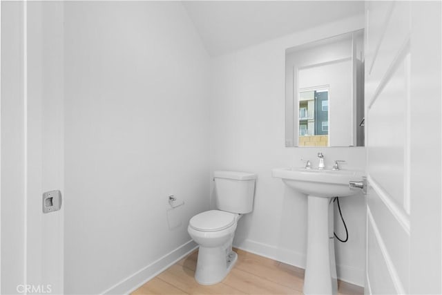 bathroom featuring toilet, hardwood / wood-style floors, and sink