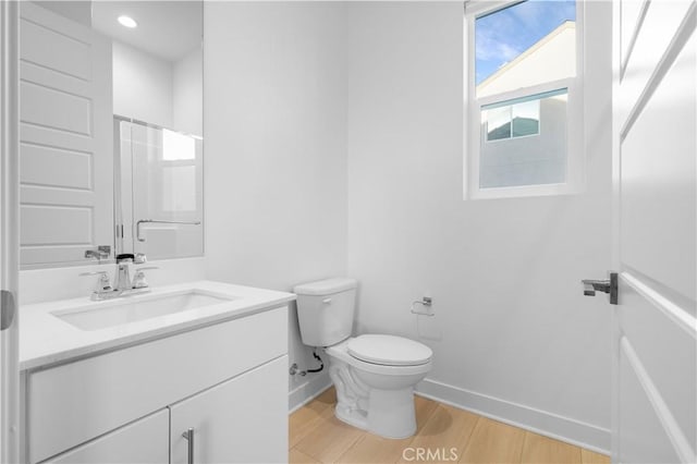 bathroom with a shower with shower door, wood-type flooring, toilet, and vanity