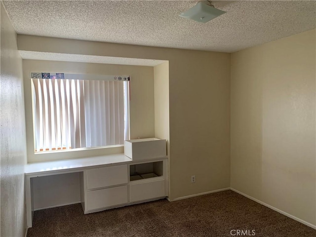 interior space with dark carpet and a textured ceiling