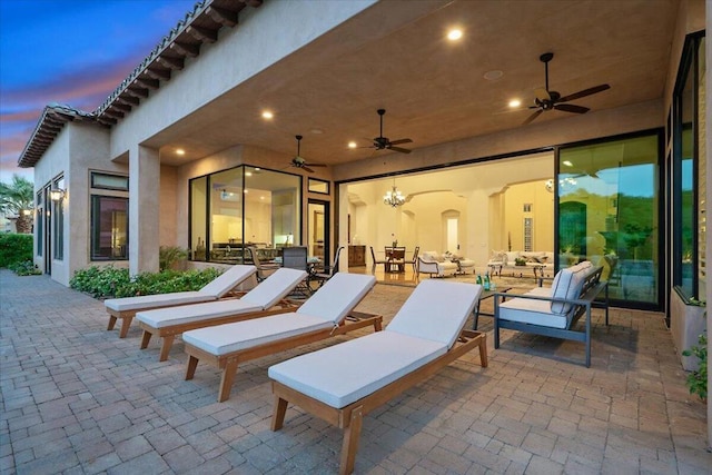 patio terrace at dusk with an outdoor living space and ceiling fan