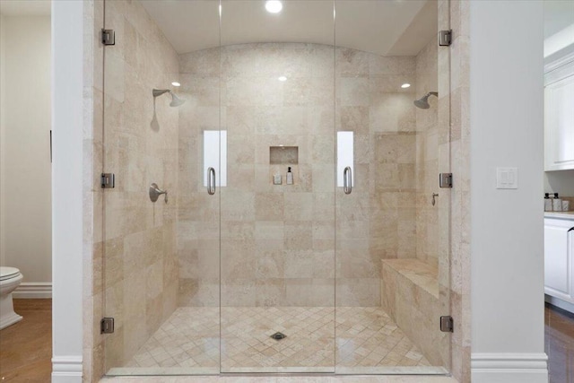 bathroom featuring an enclosed shower and toilet