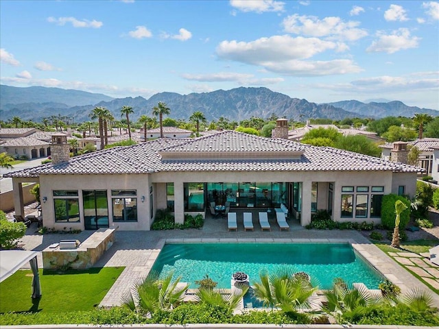 rear view of property featuring a patio area and a mountain view