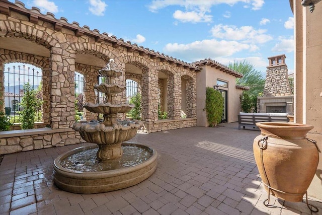 view of patio with exterior fireplace