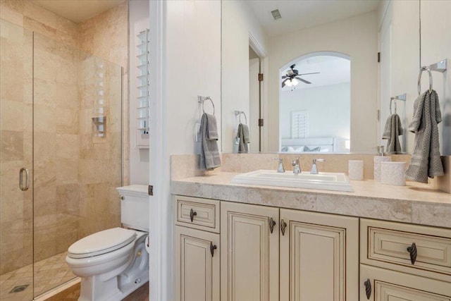 bathroom featuring toilet, ceiling fan, an enclosed shower, and vanity