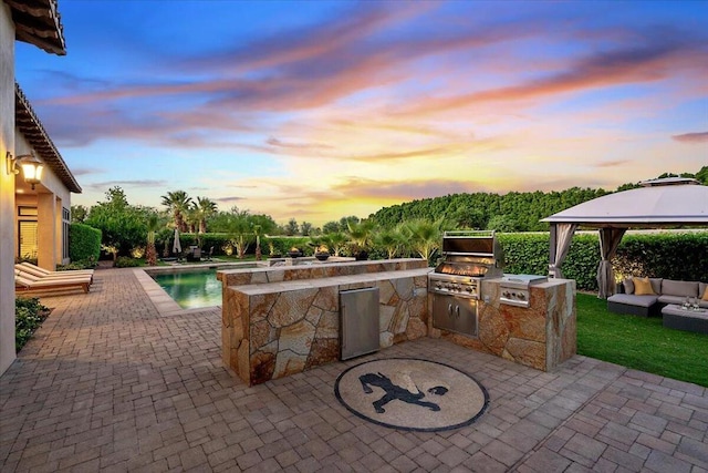 patio terrace at dusk with a gazebo, an outdoor living space, area for grilling, and a grill