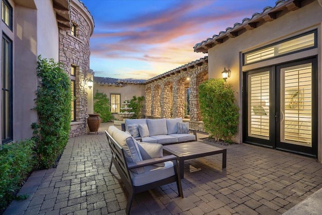 patio terrace at dusk featuring outdoor lounge area and french doors