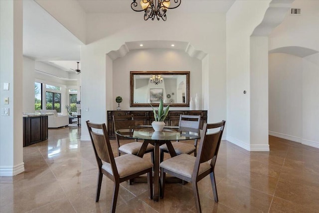 dining area featuring ceiling fan with notable chandelier