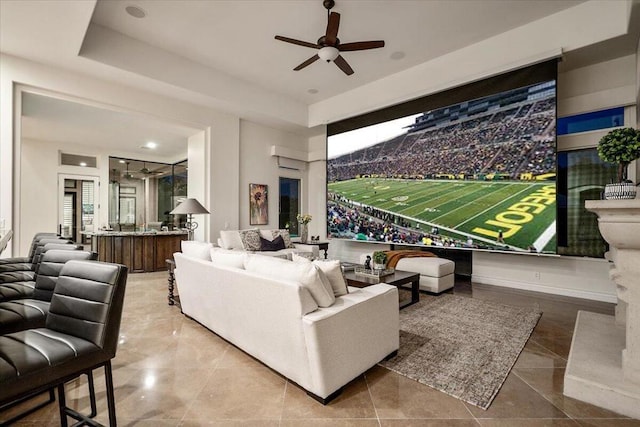 living room with ceiling fan and a tray ceiling