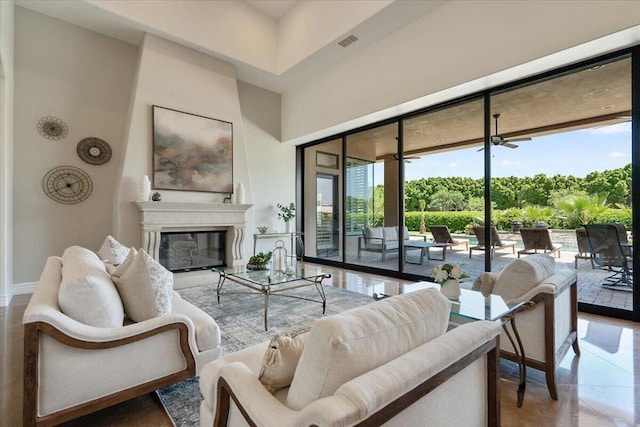 living room with ceiling fan, a healthy amount of sunlight, a towering ceiling, and floor to ceiling windows