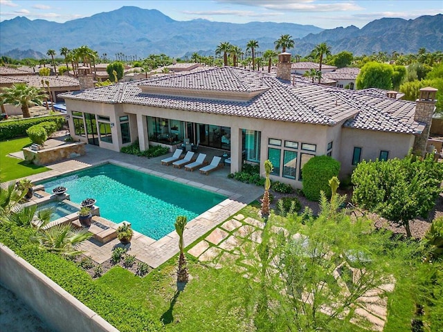 view of pool featuring a mountain view, an in ground hot tub, and a patio