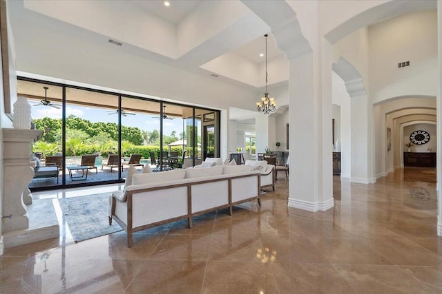 living room with a towering ceiling and a chandelier