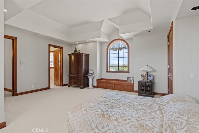 bedroom featuring a tray ceiling and light colored carpet