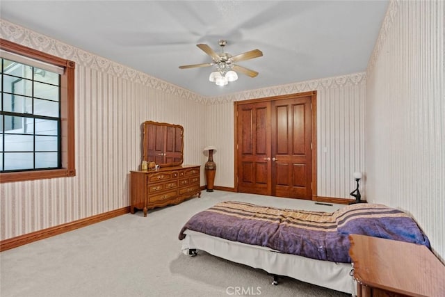 carpeted bedroom featuring ceiling fan and a closet