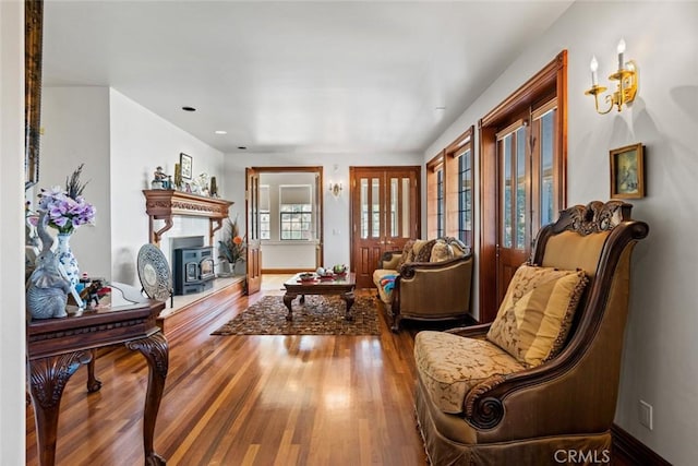 living room featuring wood-type flooring and a wood stove