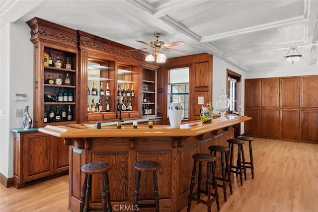 bar featuring ceiling fan, light hardwood / wood-style flooring, coffered ceiling, and sink