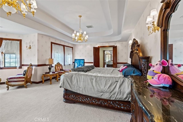 bedroom featuring carpet, an inviting chandelier, and a raised ceiling