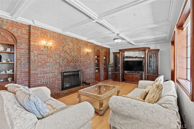 living room with a fireplace, light hardwood / wood-style floors, coffered ceiling, and brick wall