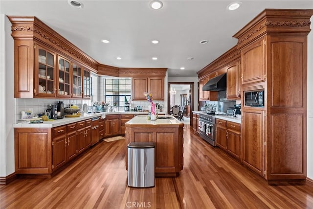 kitchen with hardwood / wood-style floors, a center island, tasteful backsplash, and black microwave