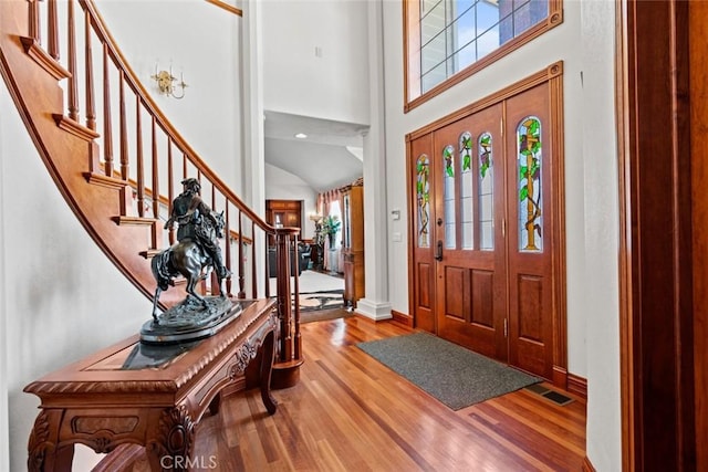 entryway featuring light wood-type flooring and high vaulted ceiling