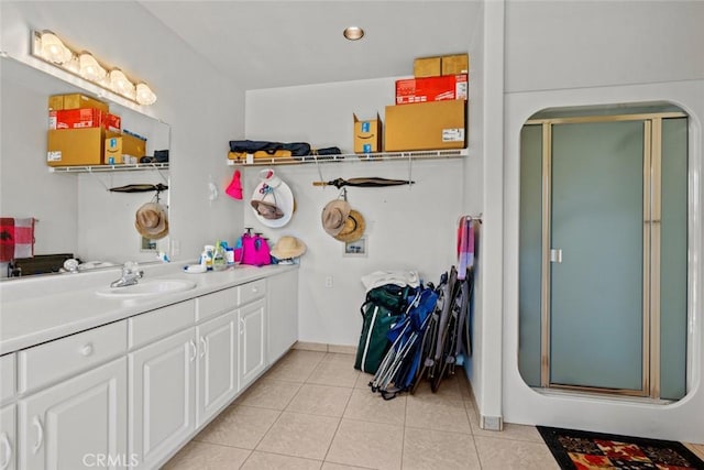 bathroom featuring tile patterned flooring, vanity, and a shower with shower door