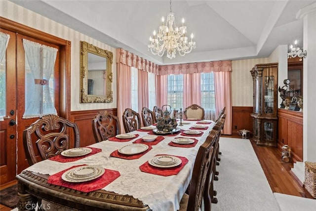 dining room featuring french doors, hardwood / wood-style flooring, lofted ceiling, and a notable chandelier