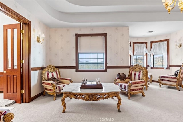 sitting room with carpet flooring and a tray ceiling