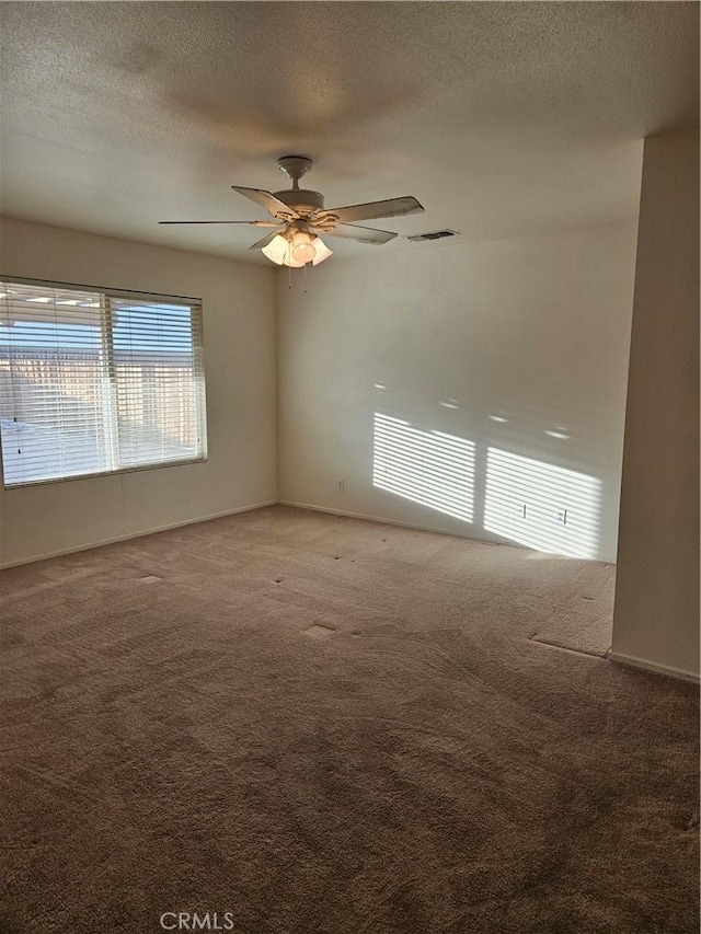 carpeted spare room with ceiling fan and a textured ceiling