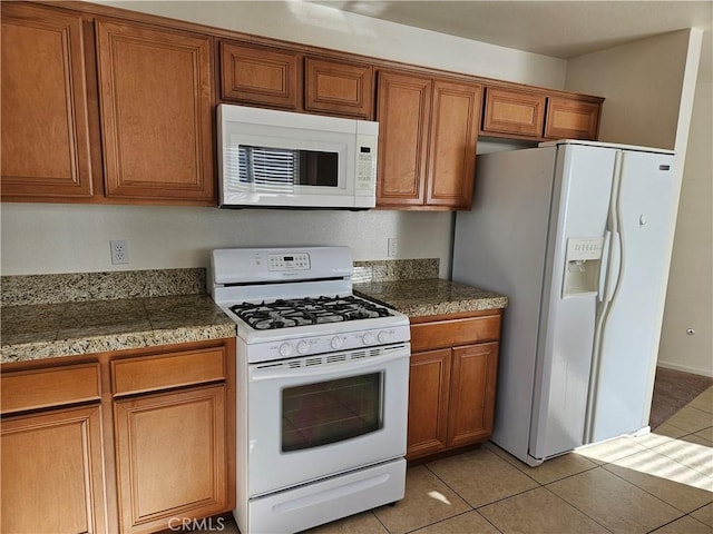 kitchen featuring light tile patterned floors and white appliances