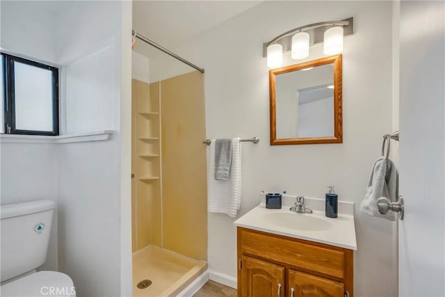 bathroom with a shower, vanity, and toilet