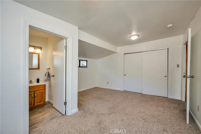 bedroom featuring light carpet, ensuite bathroom, and a closet