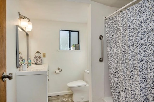 bathroom featuring vanity, toilet, wood-type flooring, and walk in shower