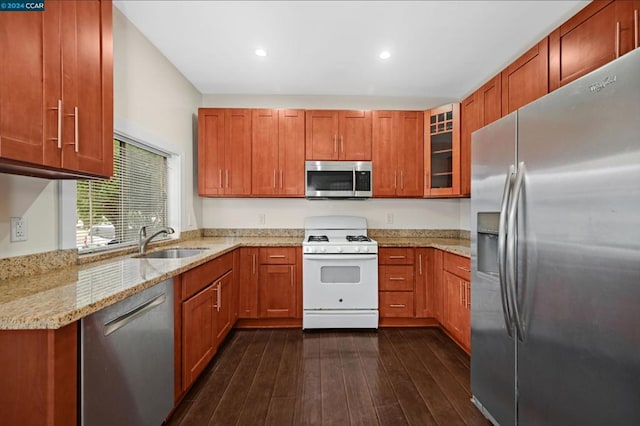 kitchen featuring light stone countertops, appliances with stainless steel finishes, dark hardwood / wood-style floors, and sink