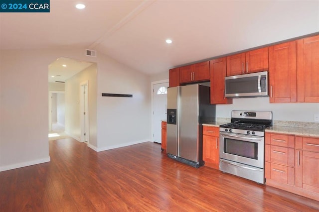 kitchen with appliances with stainless steel finishes, dark hardwood / wood-style floors, and lofted ceiling