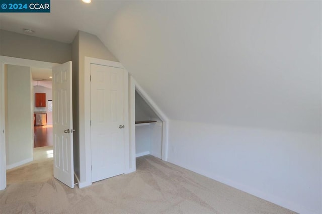 bonus room featuring light carpet and vaulted ceiling