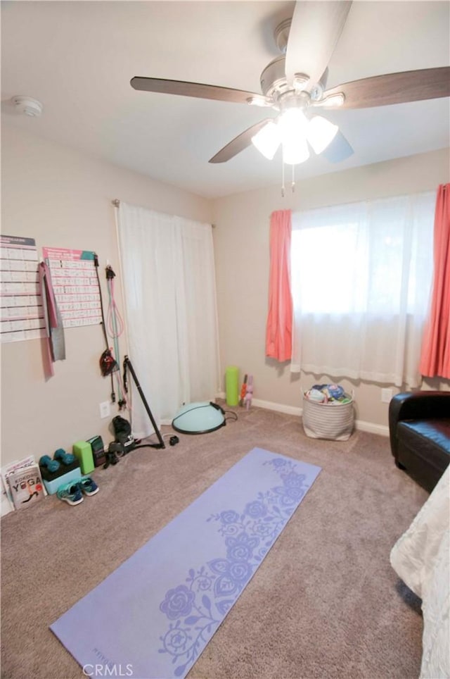 workout room featuring light colored carpet and ceiling fan