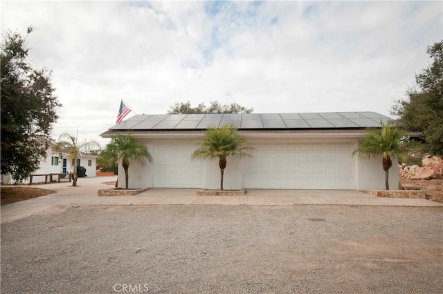 view of front facade featuring solar panels and a garage