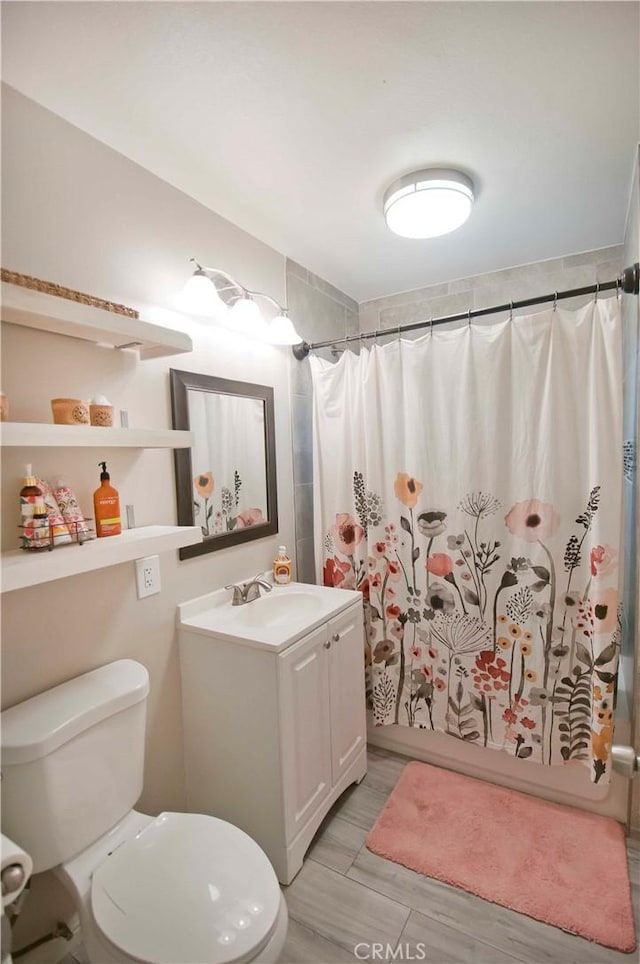 full bathroom with wood-type flooring, vanity, toilet, and shower / tub combo with curtain