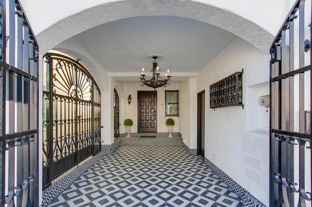 hallway featuring a textured ceiling, a wealth of natural light, and a notable chandelier